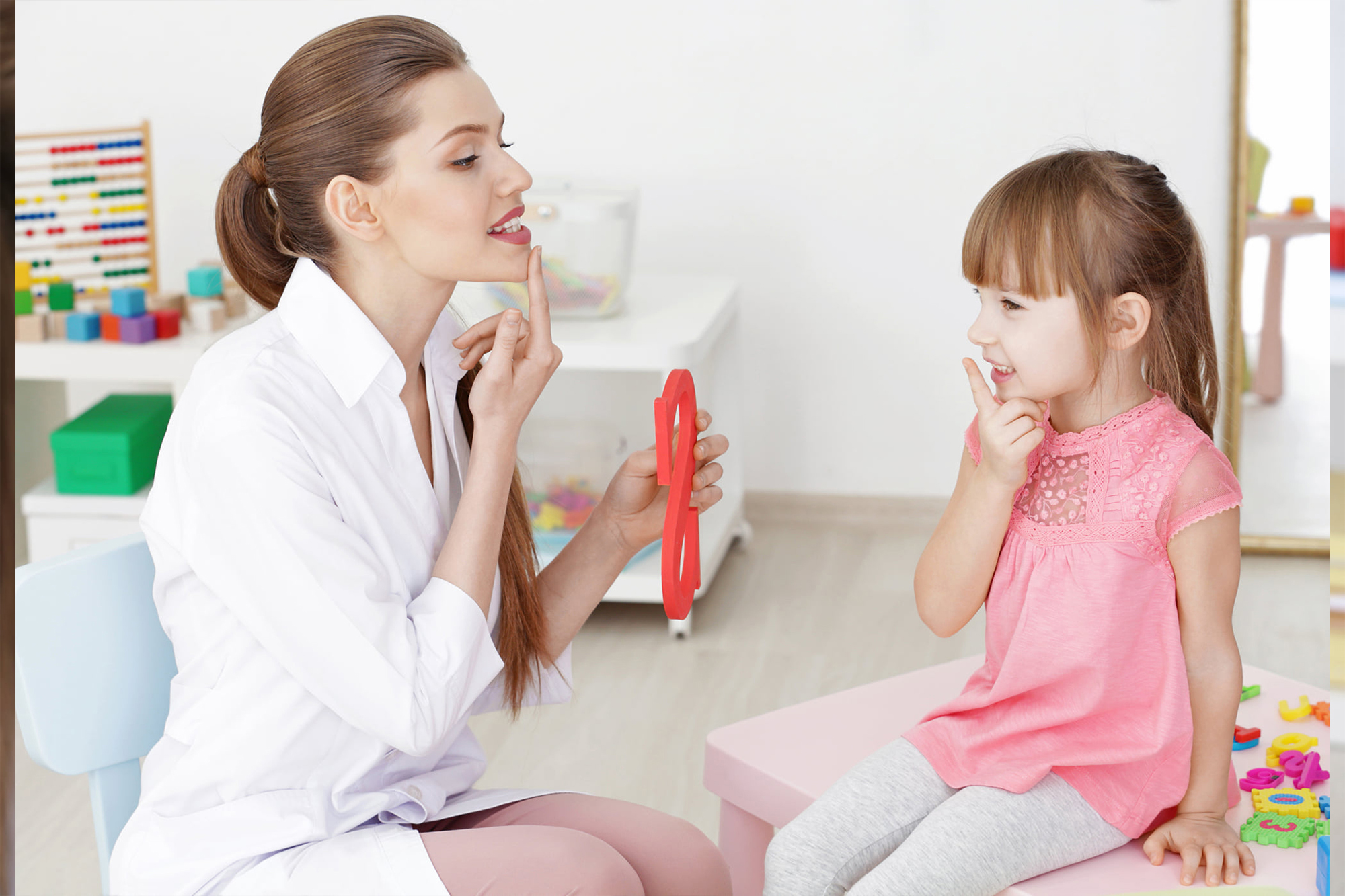 أخصائية نفسية ترتدي حجاب تتفاعل بلطف مع طفل